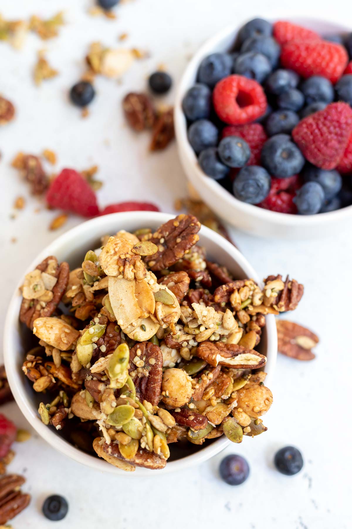 keto granola and fresh berries in white bowls