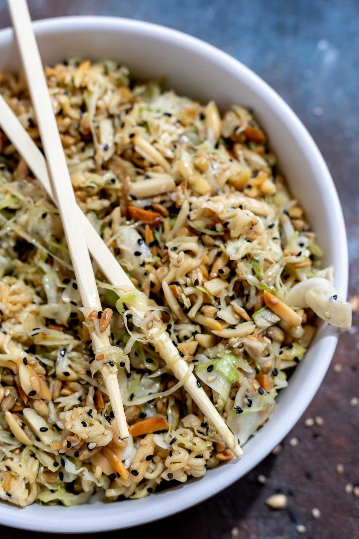 ramen coleslaw in white bowl with wooden chopsticks on top