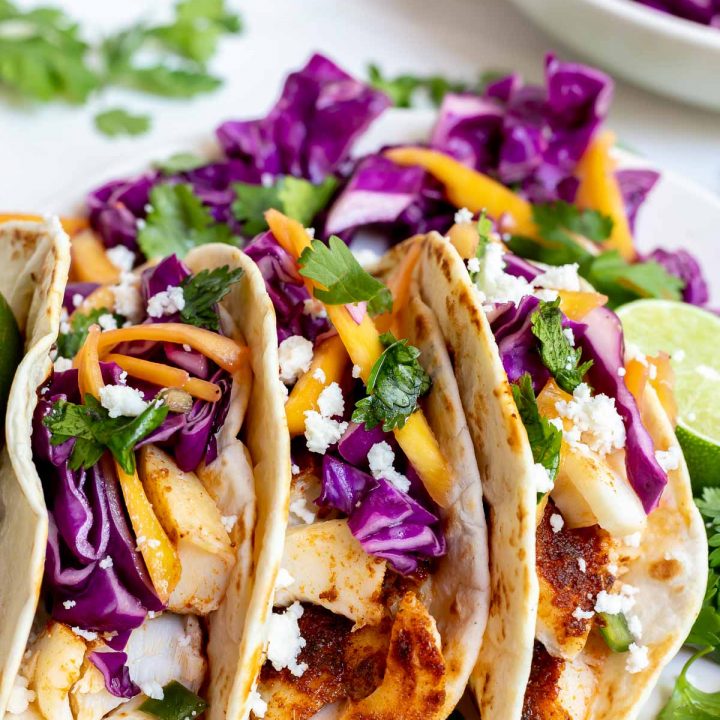 three fish tacos on white plate