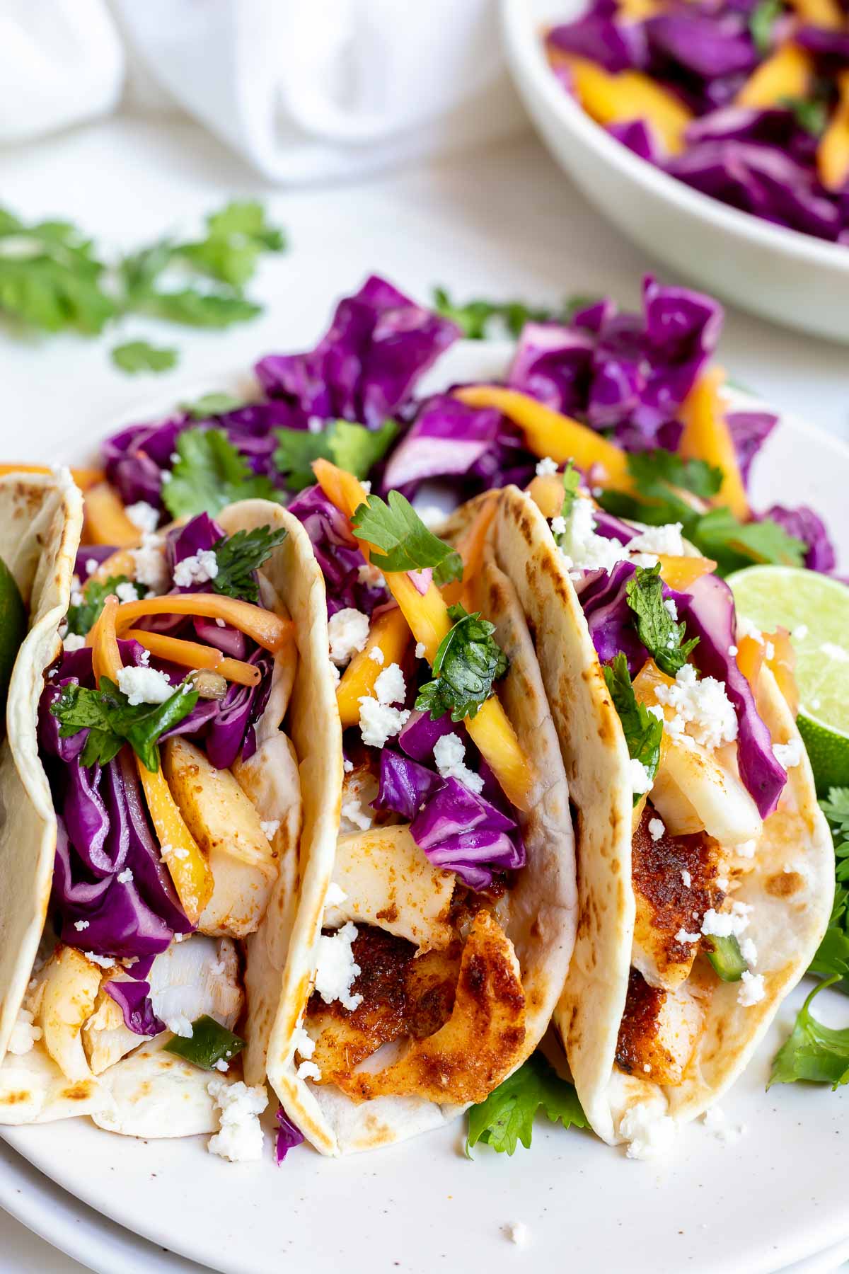 three fish tacos on white plate