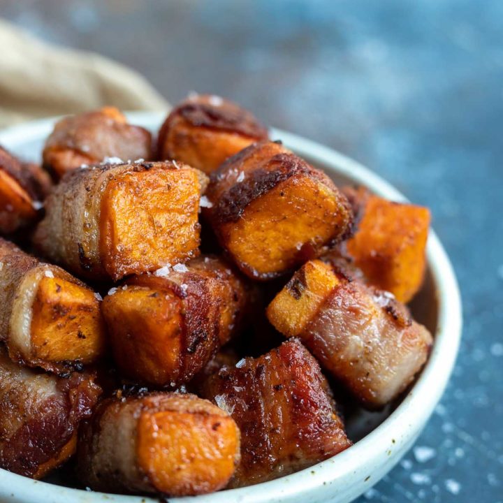 roasted sweet potatoes wrapped in bacon in white dish