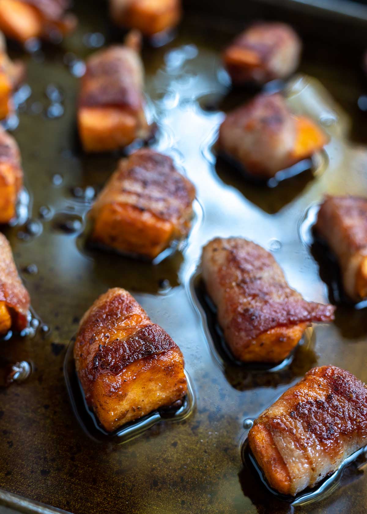 cooked sweet potatoes and bacon on baking sheet