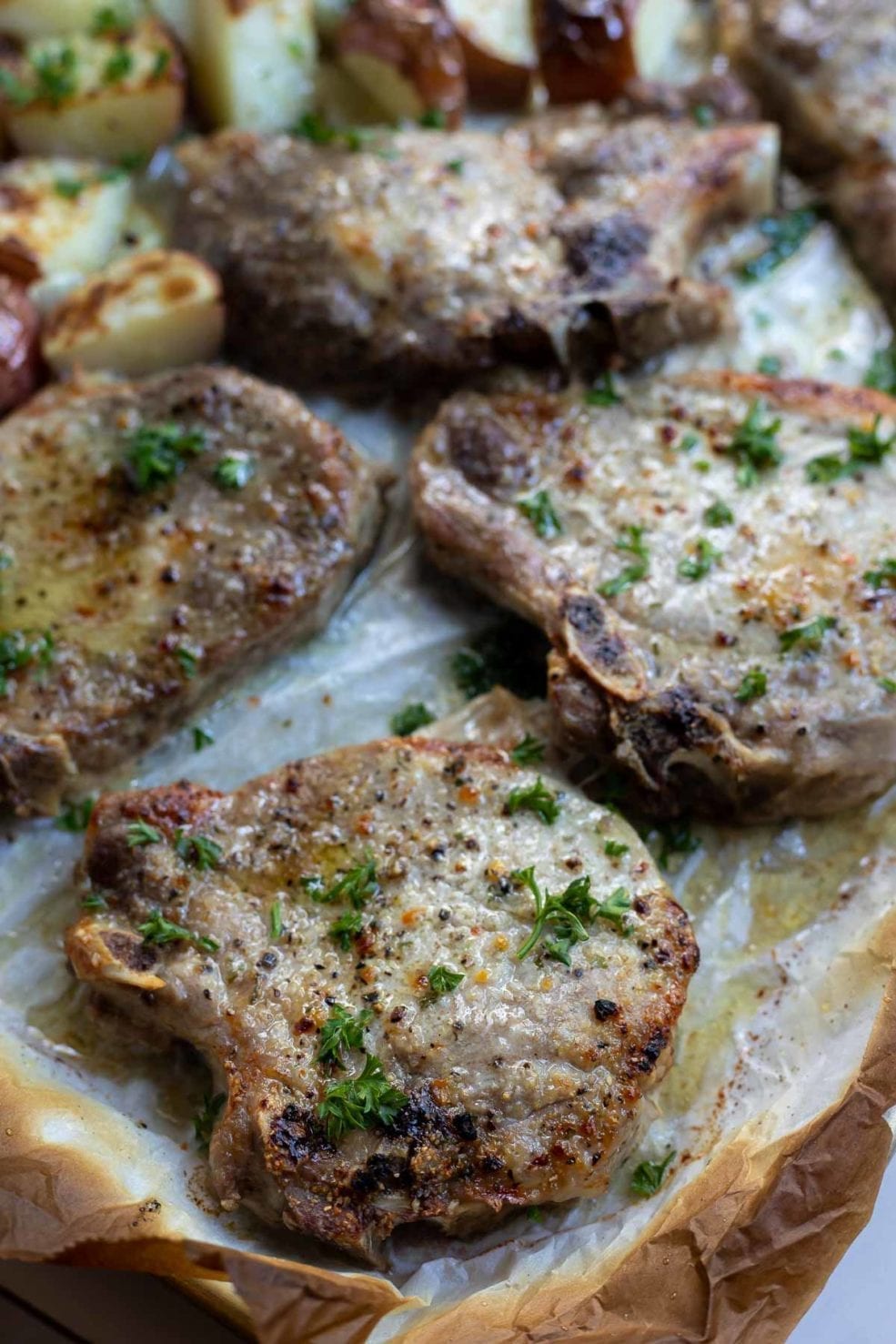 baked pork chops on parchment paper lined sheet pan