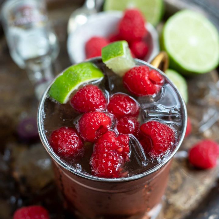 raspberry mule in copper cup with mini whiskey bottle on the side
