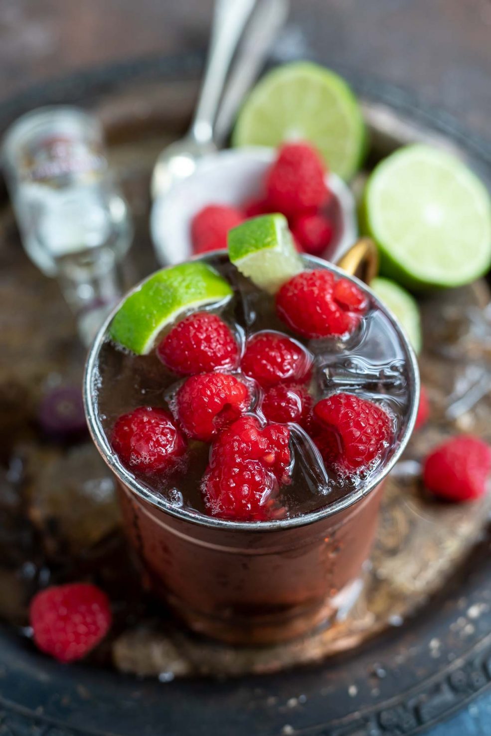 raspberry mule in copper cup with mini whiskey bottle on the side