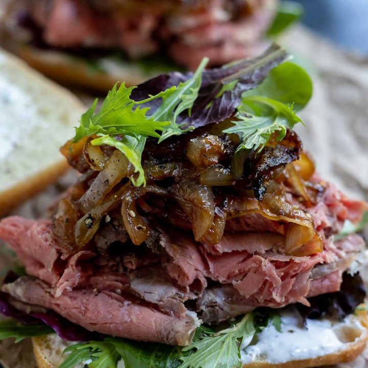 open faced sandwich with prime rib, caramelized onions and greens