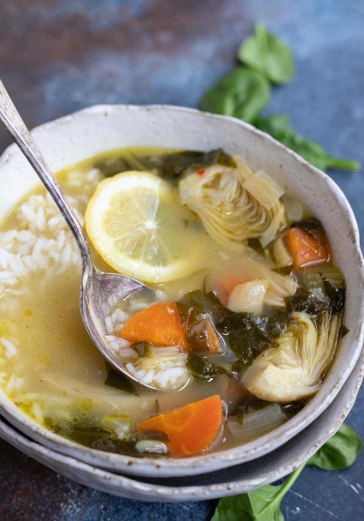 vegetable chicken soup in white bowl with soup spoon