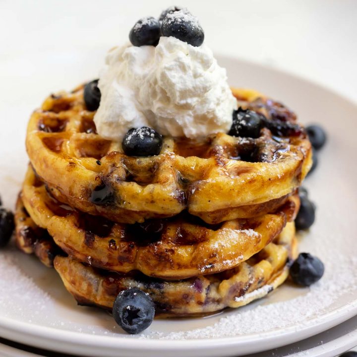 stacked waffles with blueberry cream and syrup