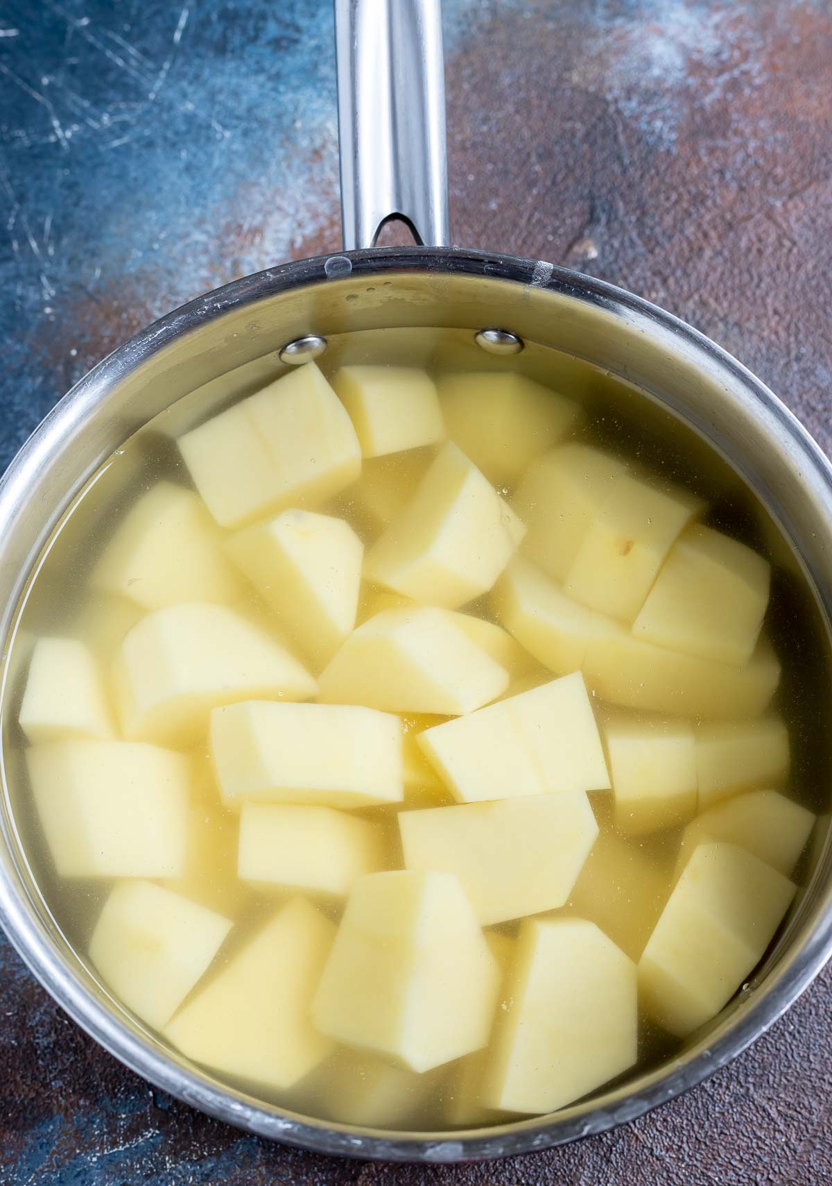 chunks of potatoes and water in metal pot