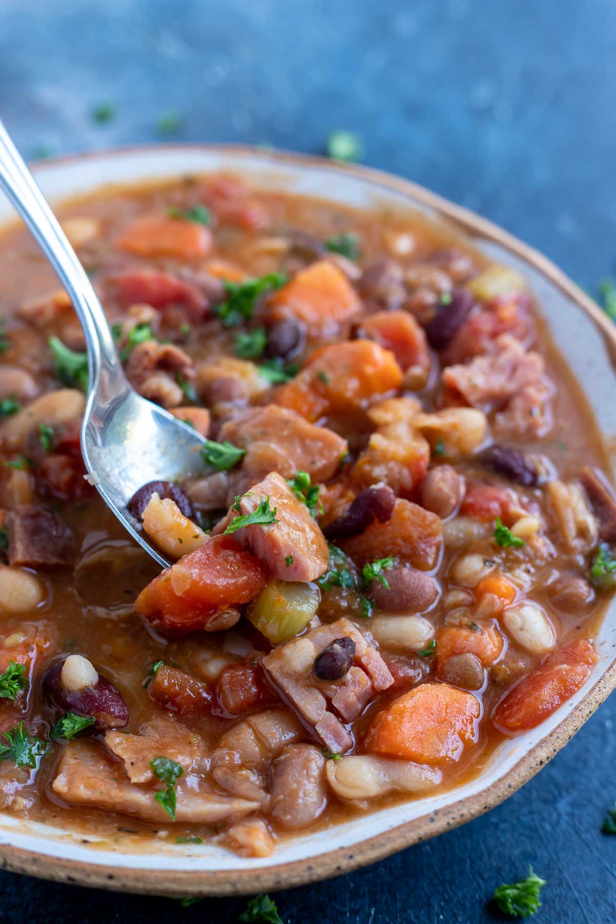 spoon scooping ng into ham bean soup