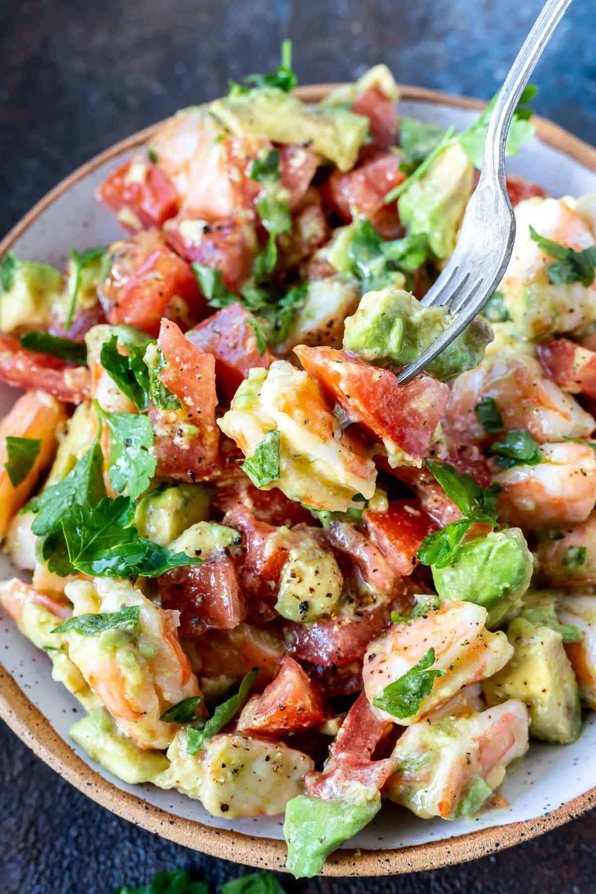 shrimp avocado salad in bowl with fork