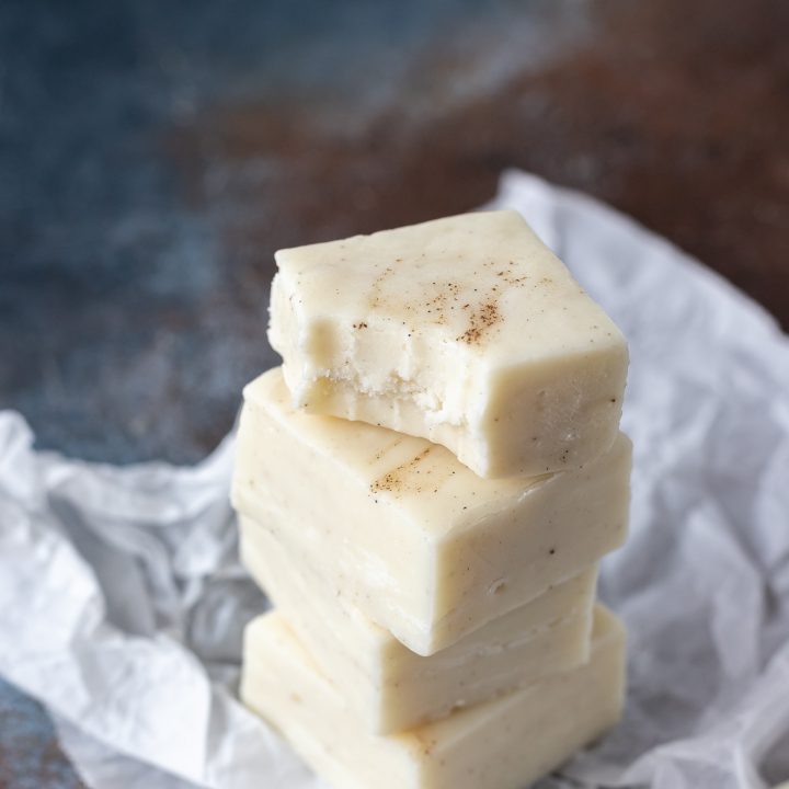 squares of fudge stacked on parchment paper