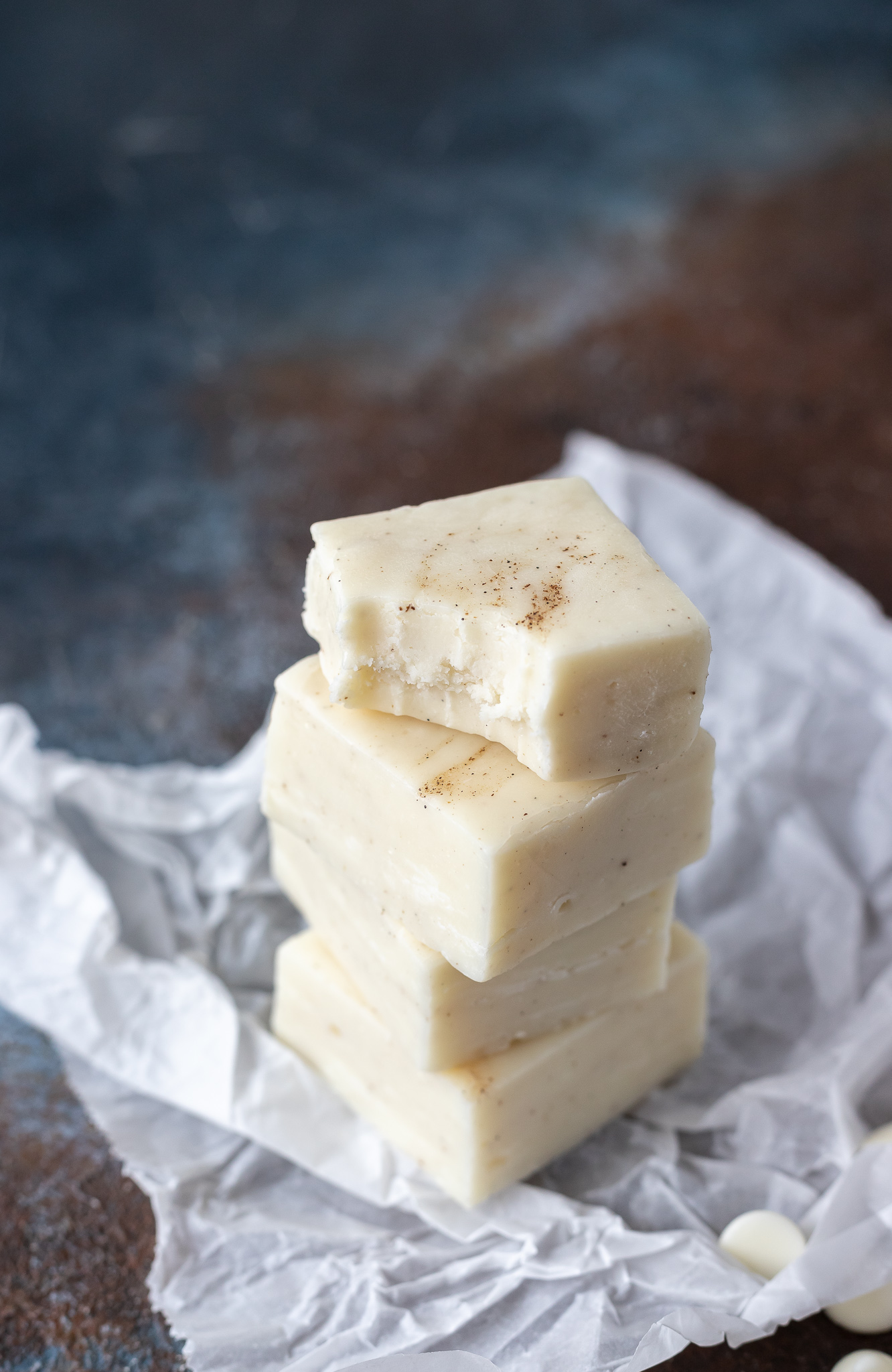 squares of fudge stacked on parchment paper