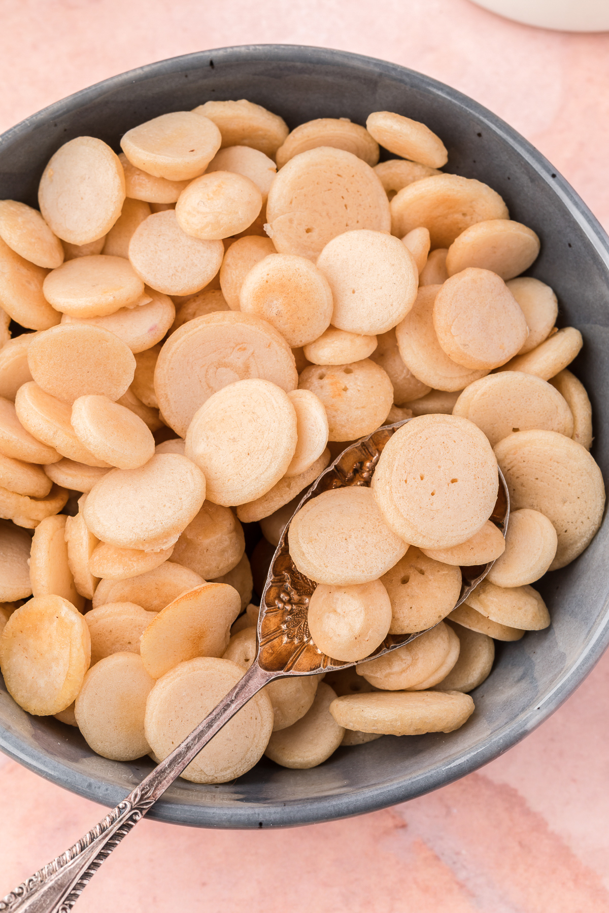 cooked pancakes cereal in bowl with spoon