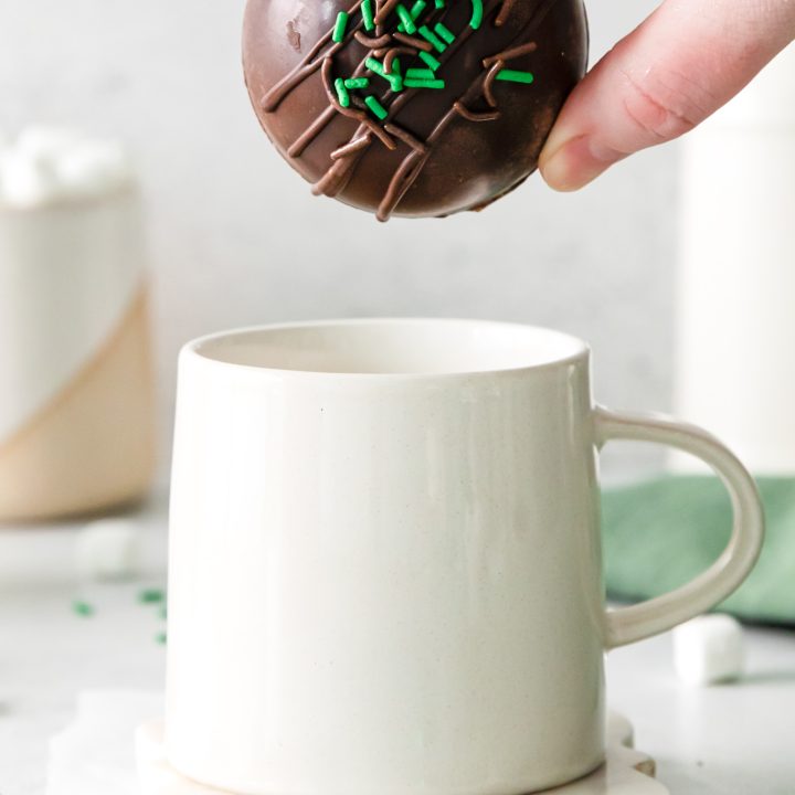 hand holding cocoa bomb over mug