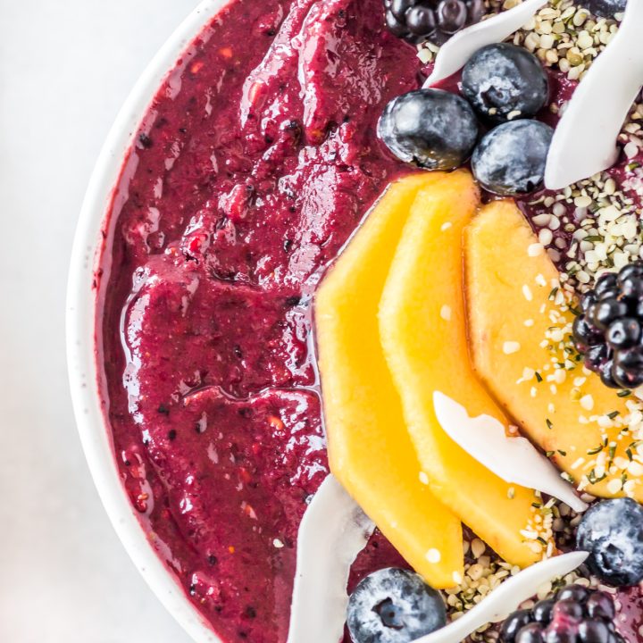 purple puree topped with fruit in white bowl