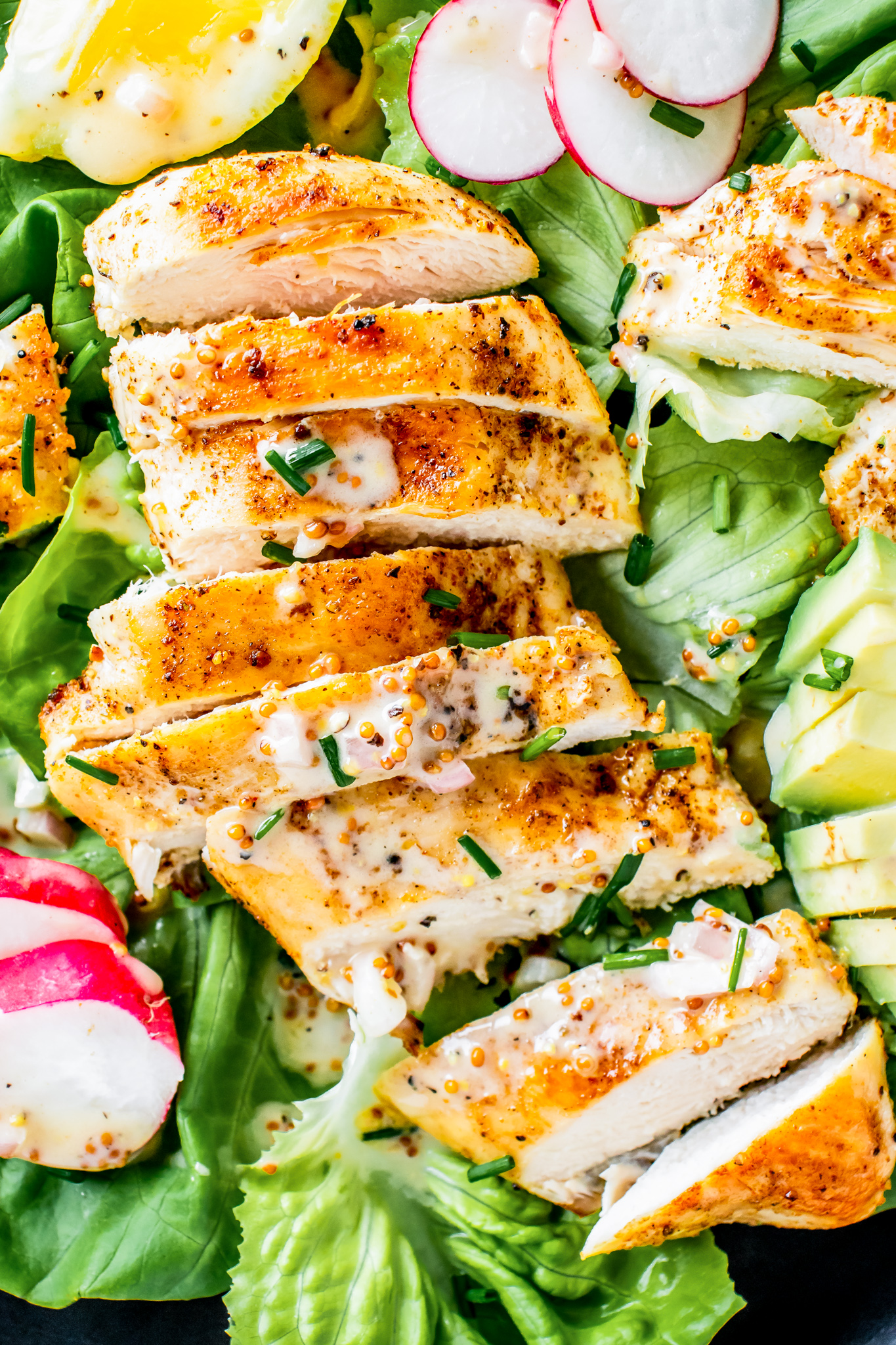 cooked sliced chicken breast on salad greens