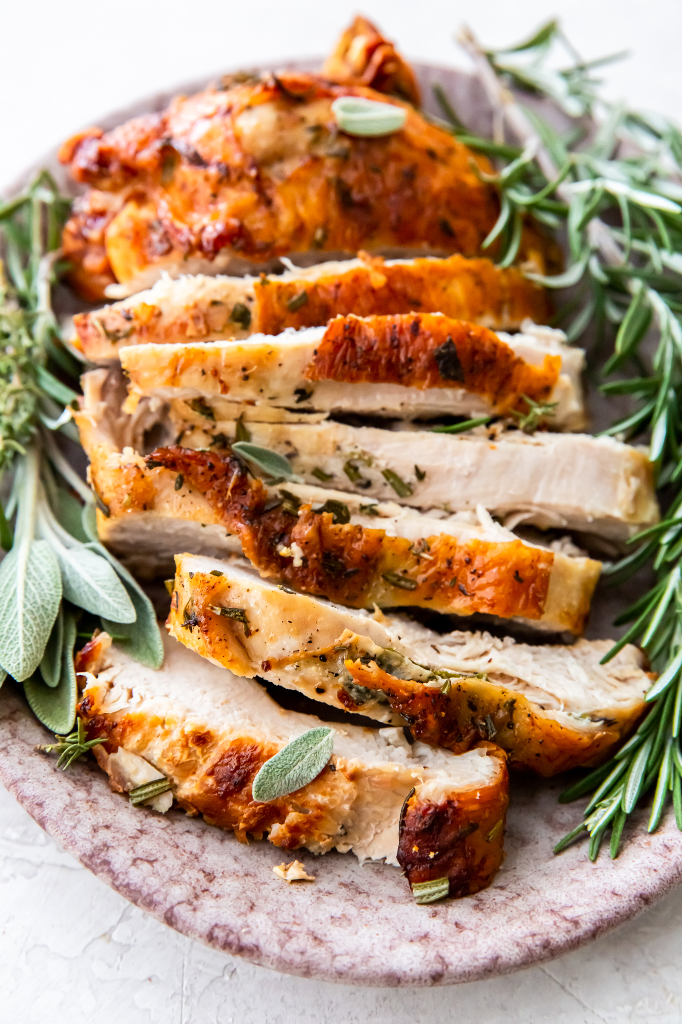 sliced turkey on platter with herbs