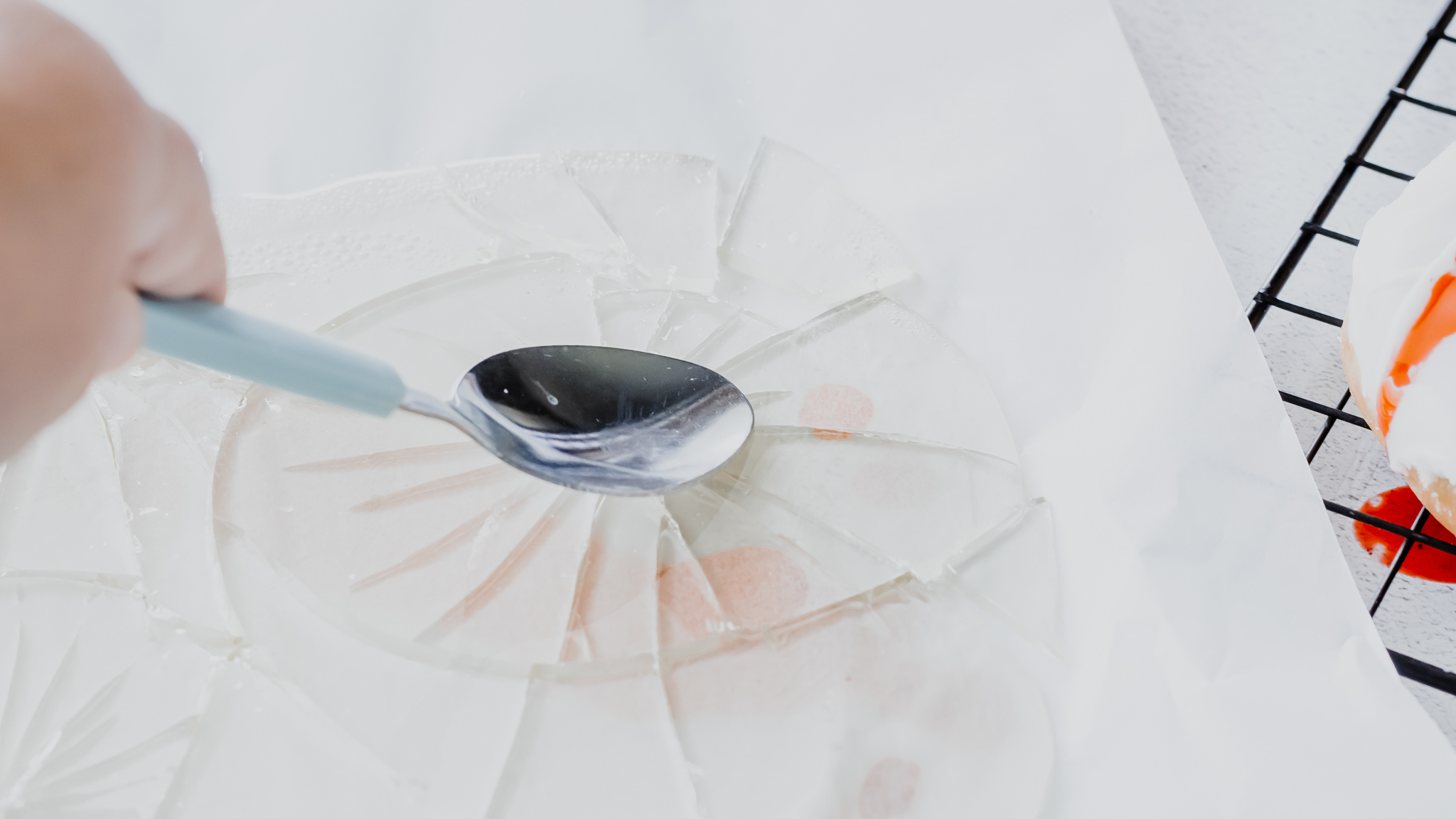 spoon cracking clear candy into broken pieces