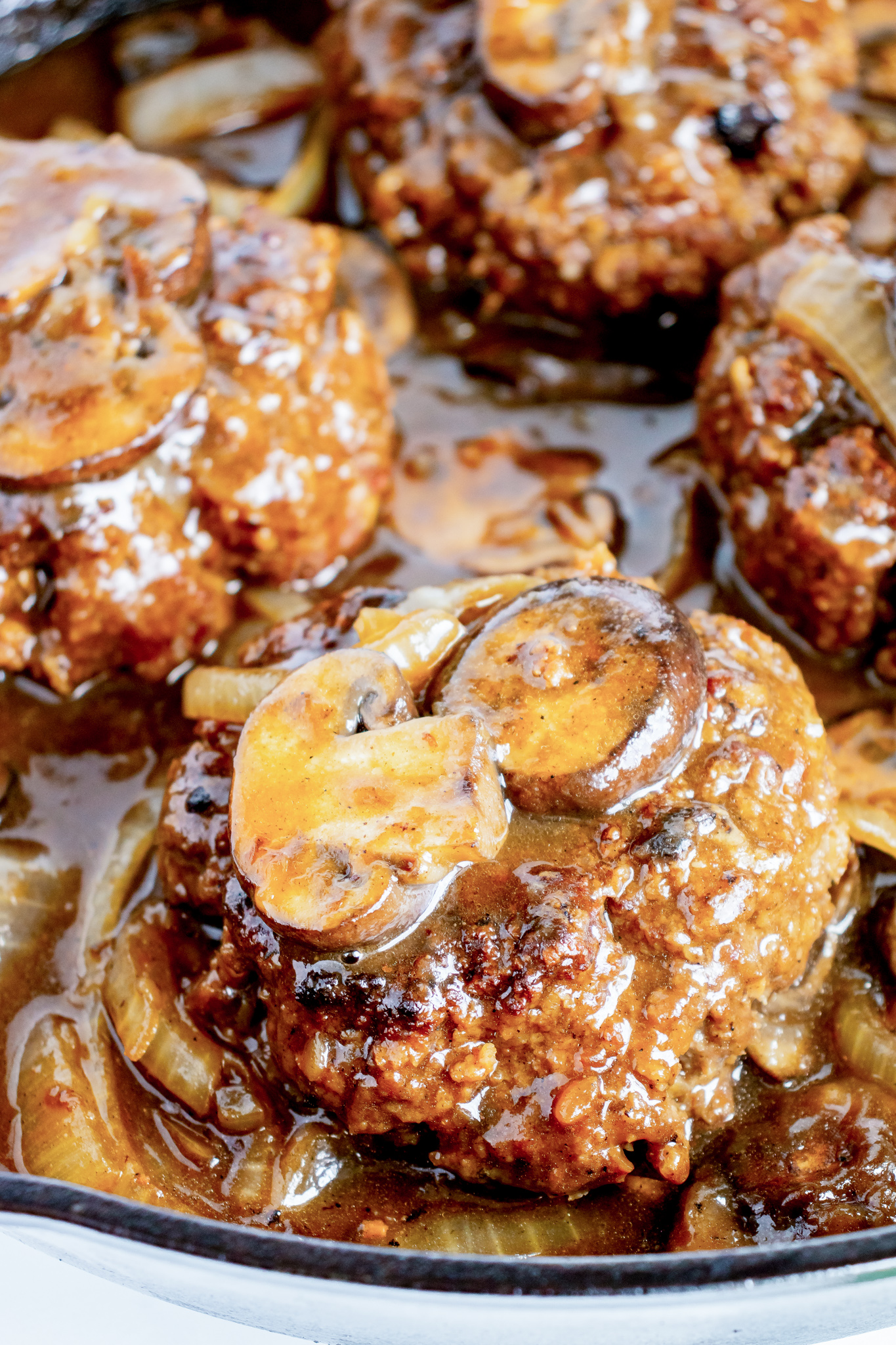 cooked hamburger topped with gravy and mushrooms