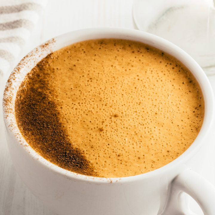 foamy tan drink in white mug