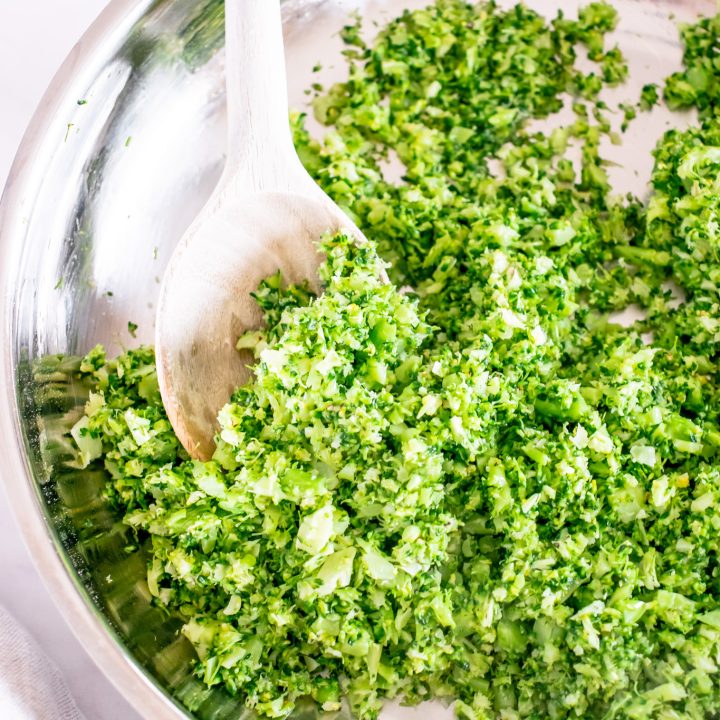 riced broccoli in pan with wooden spoon