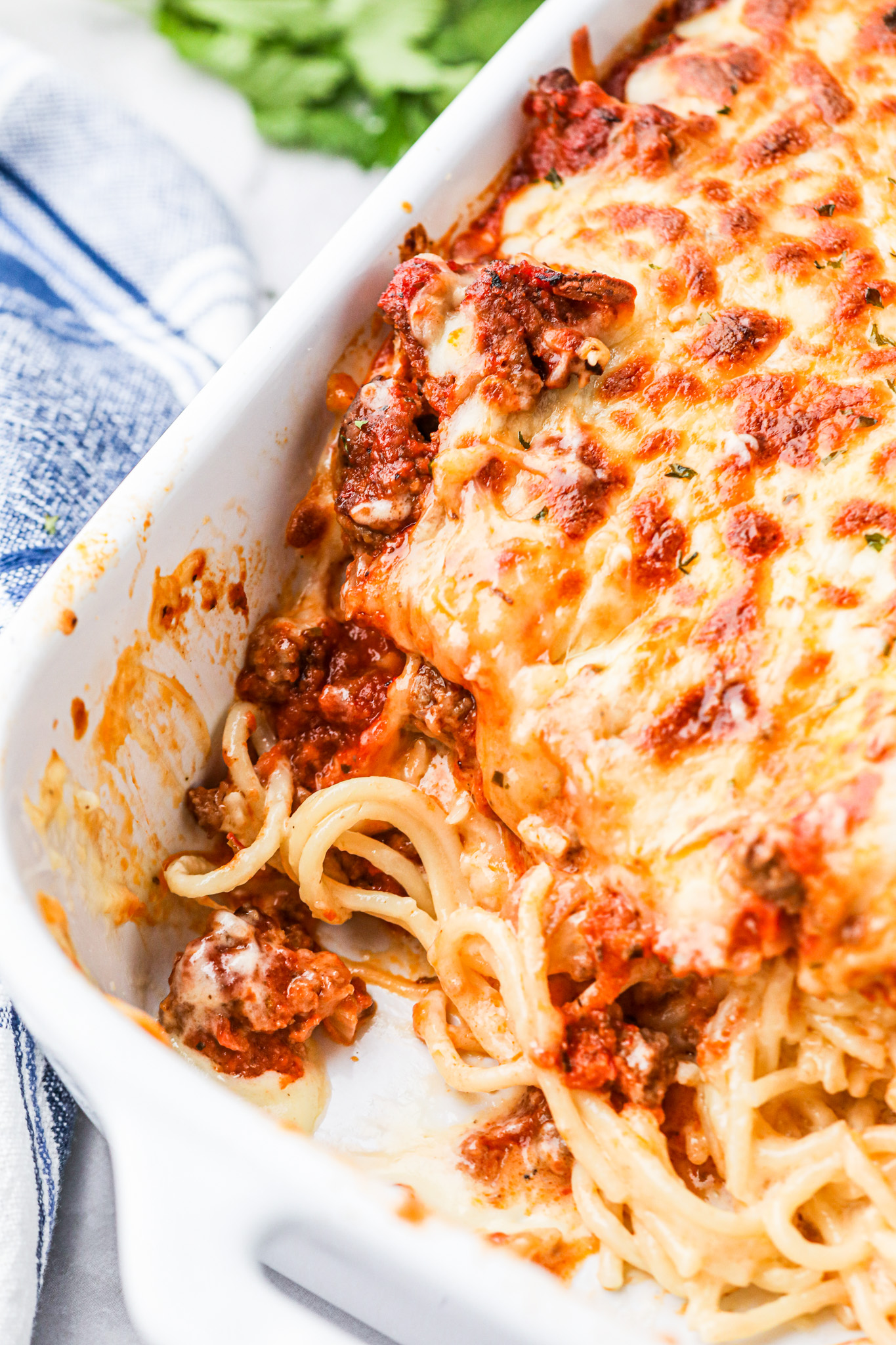 cheesy spaghetti in white casserole dish