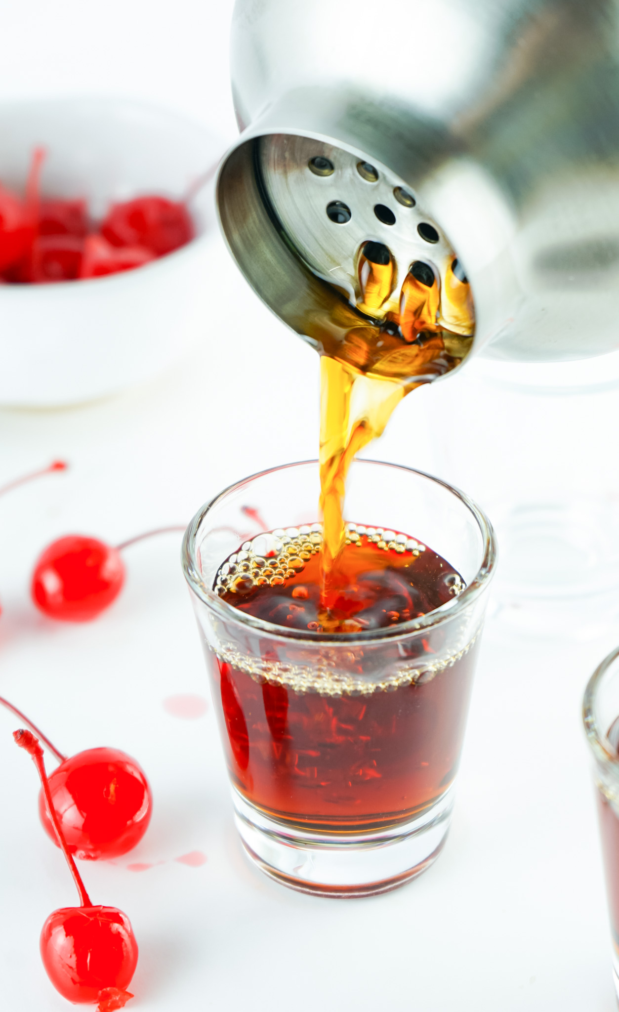 shot being poured from cocktail shaker