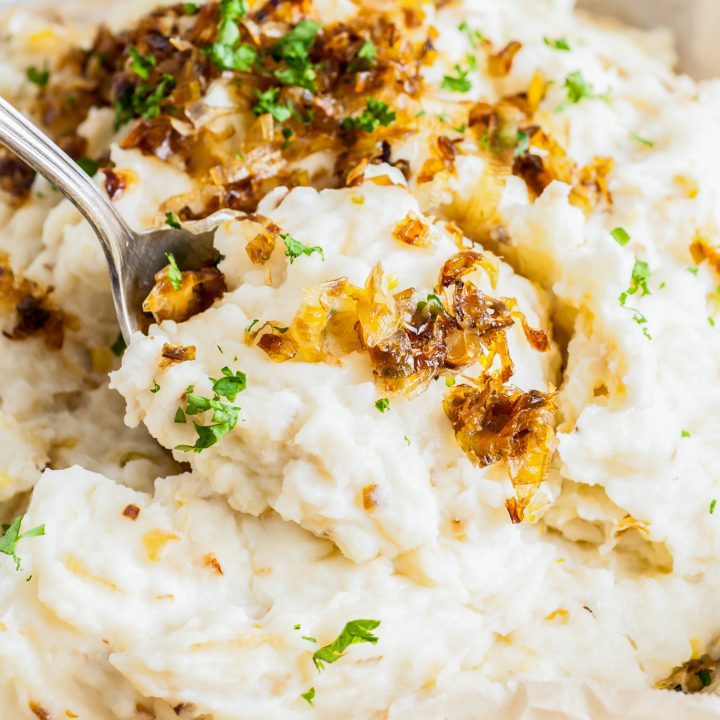 mashed potatoes being scooped with serving spoon
