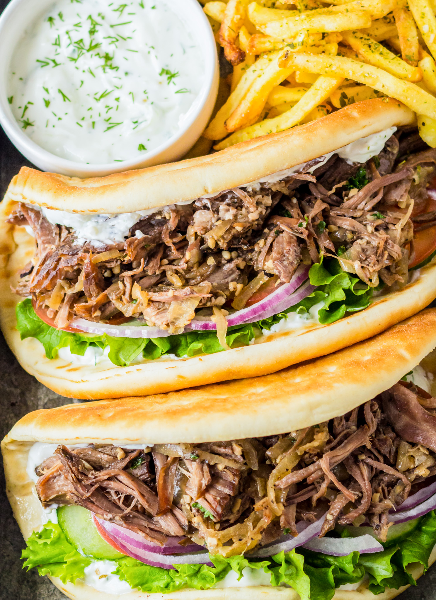 two gyros next to fries
