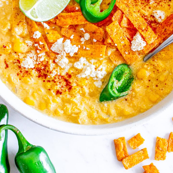 yellow soup topped with lime, cheese and jalapenos