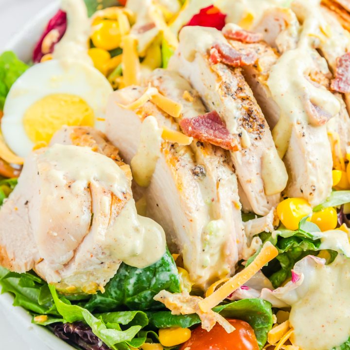 salad topped with sliced grilled chicken