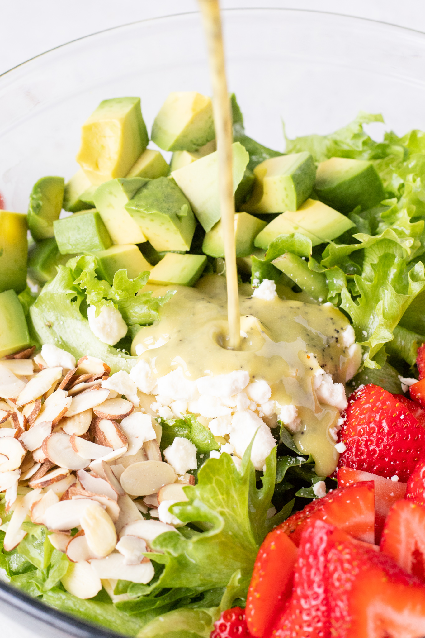 dressing being poured over salad