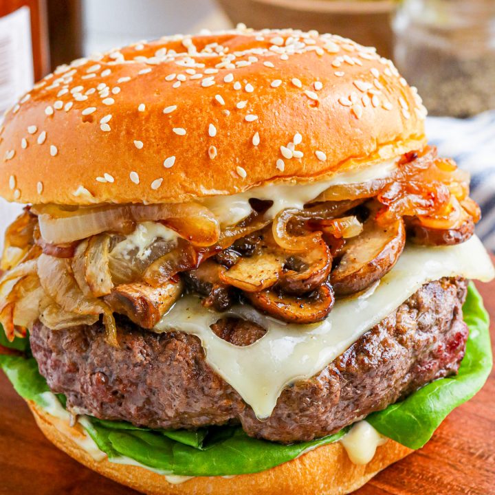 burger on bun topped with cheese and mushrooms