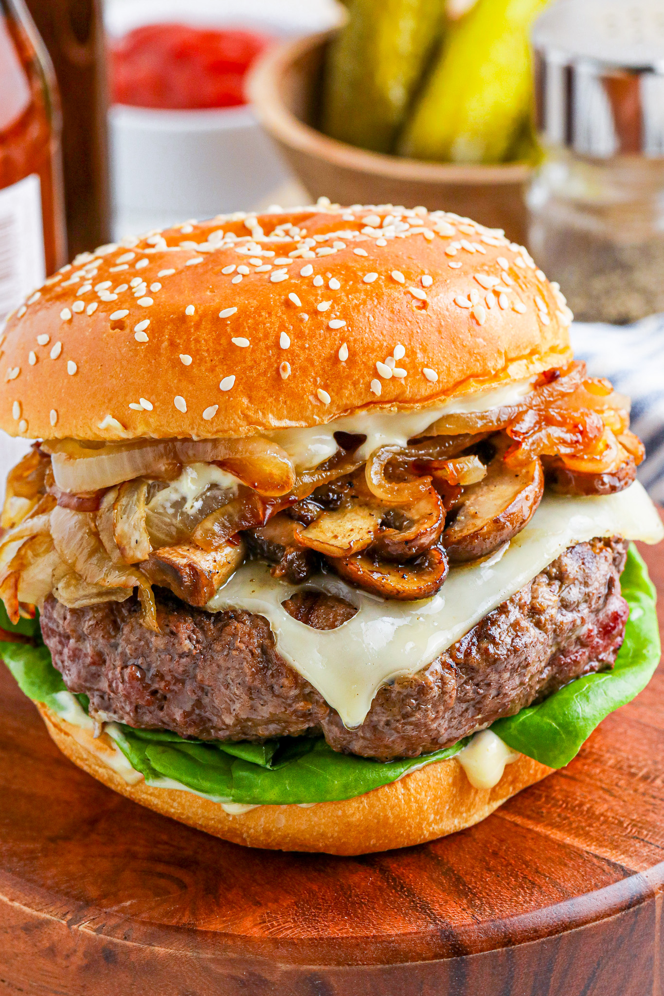 burger on bun topped with cheese and mushrooms