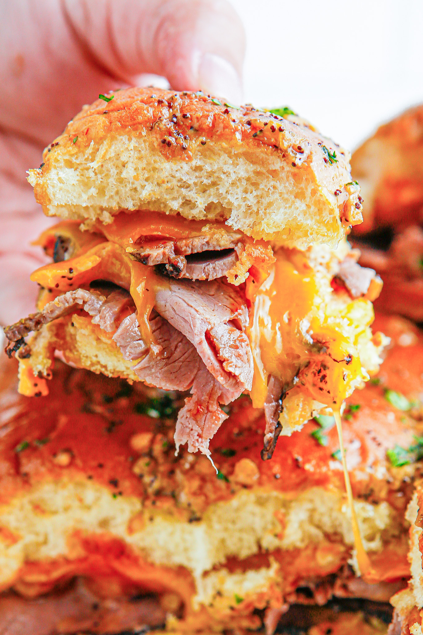 hand holding beef and cheddar slider