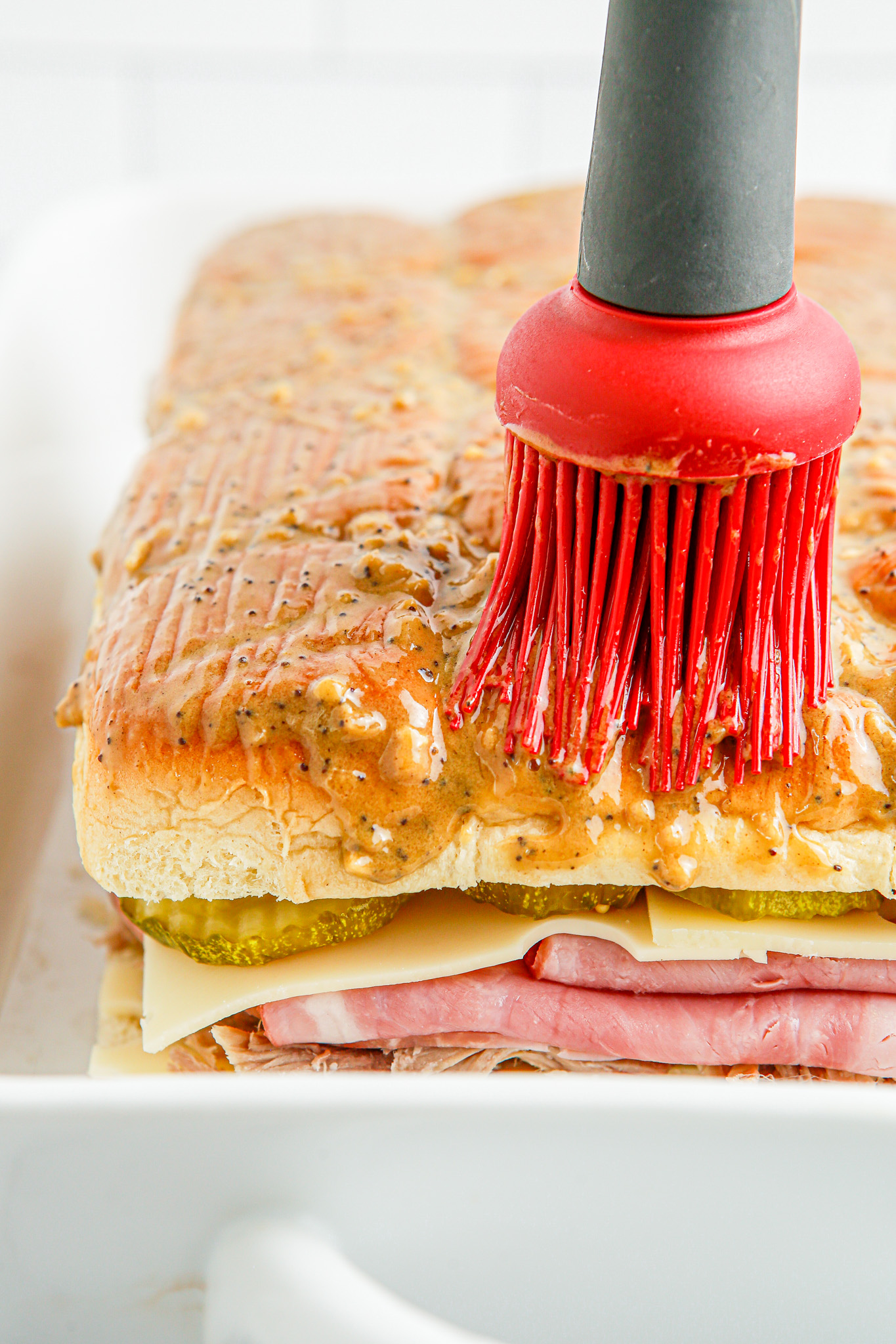 brushing butter topping onto rolls