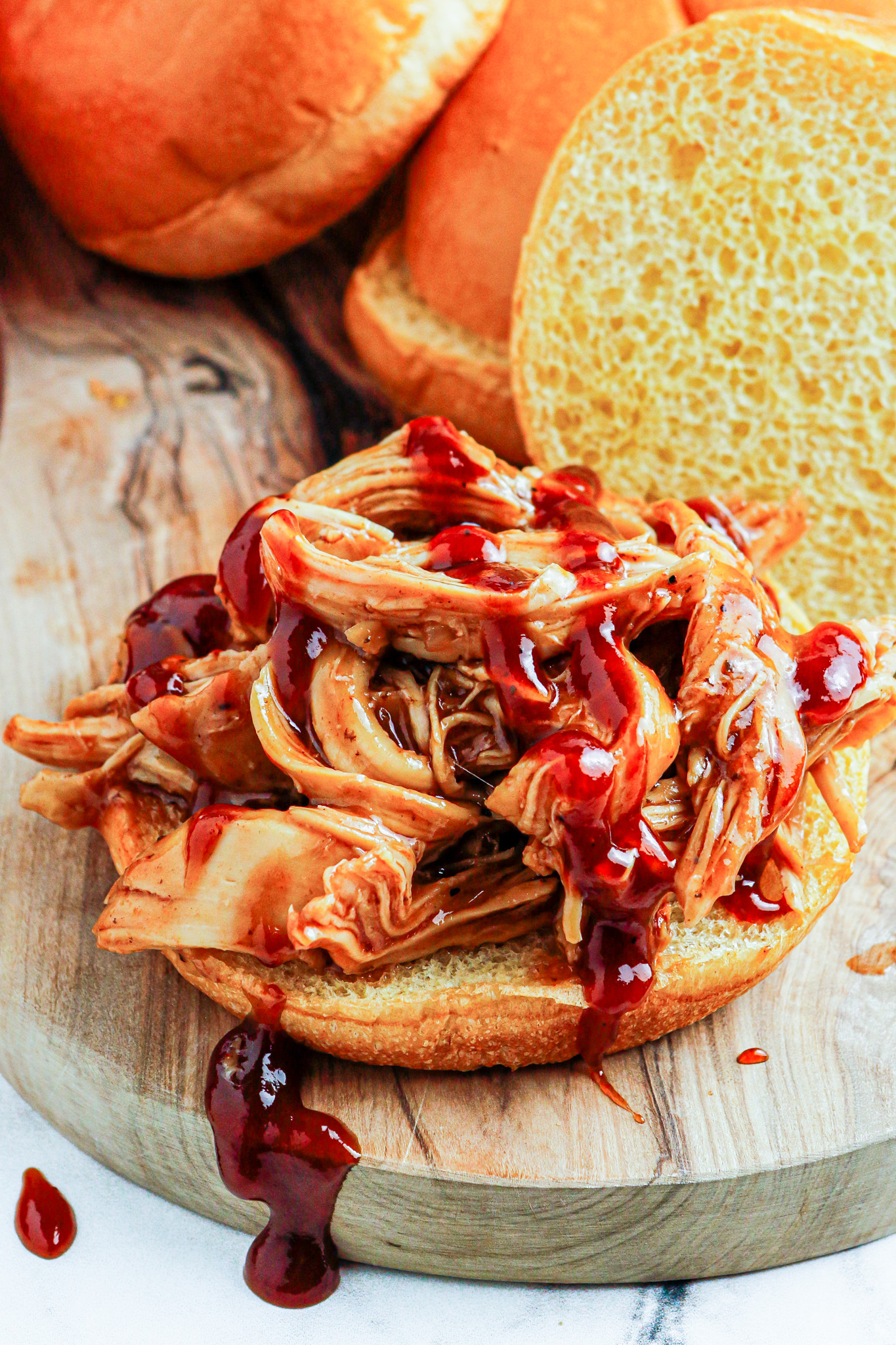 shredded chicken and sauce on bun