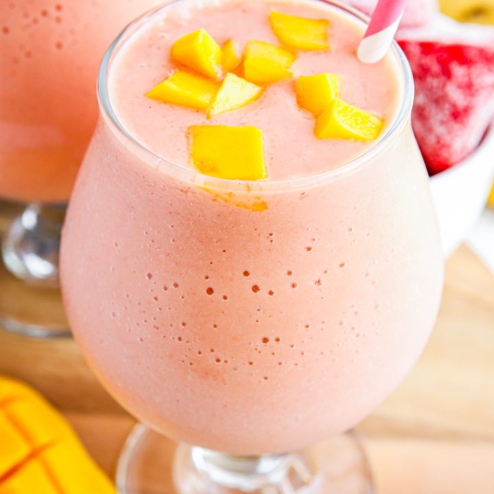 pink smoothie topped with mango chunks
